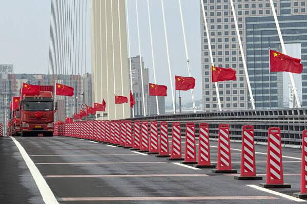 Camión y banderas de China sobre el puente mostrado en la cobertura de la apertura del paso fronterizo en el río Yalu.