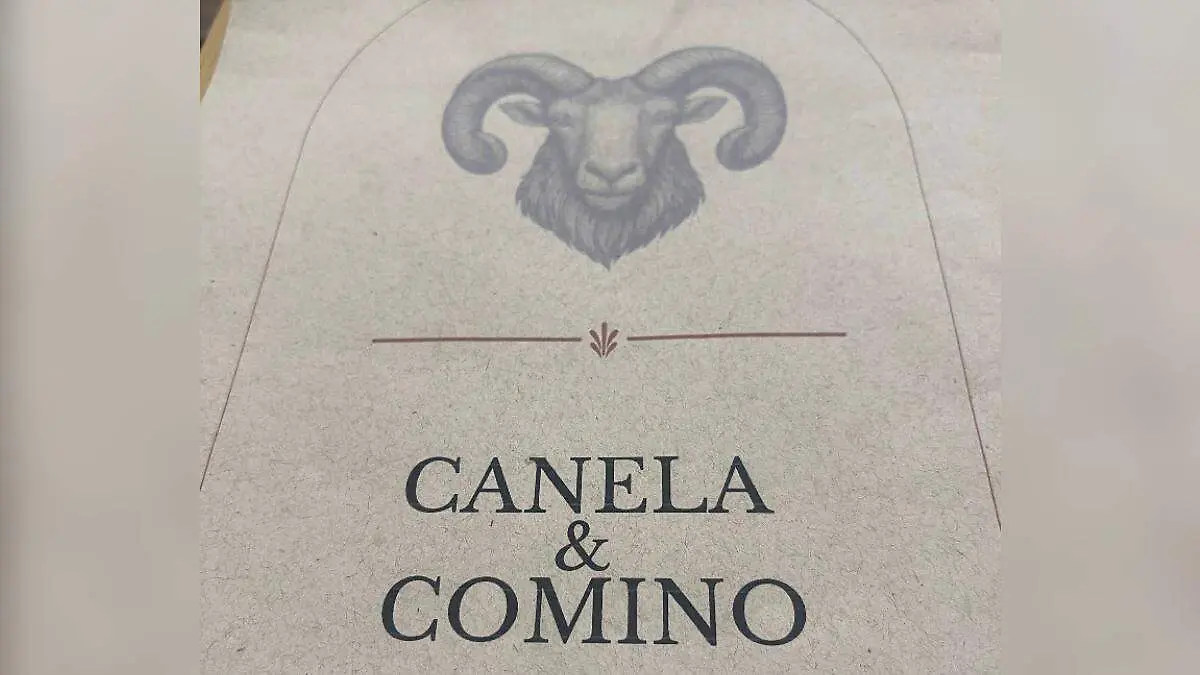 Letrero del restaurante Canela y Comino, con el símbolo de un carnero encima del nombre.
