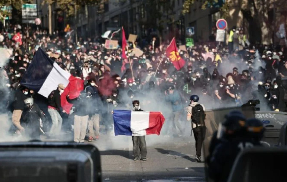 Manifestantes en una calle de Francia con banderas, humo y presencia policial; fotografía de archivo.