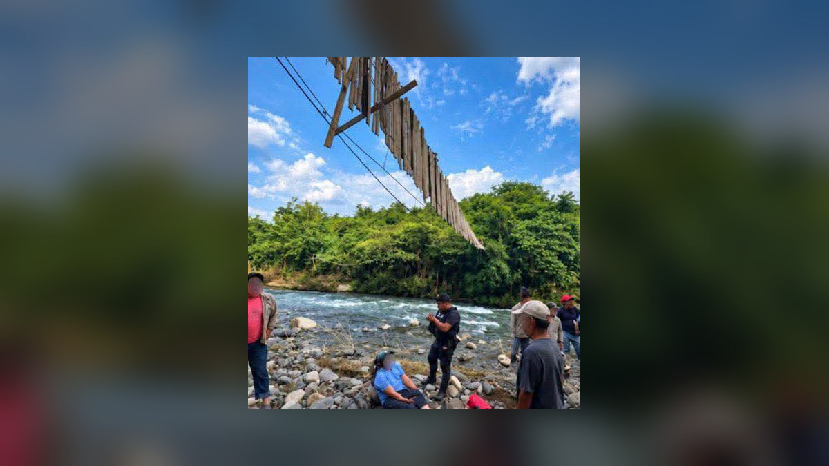 Imagen proporcionada sobre el puente colgante sobre un río, con personas junto al cauce en Hueytamalco.