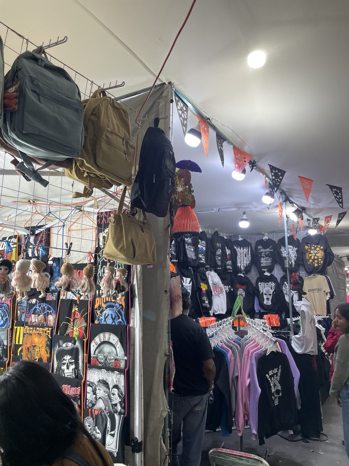 Exhibición de ropa, mochilas y otros artículos dentro de las estructuras temporales.